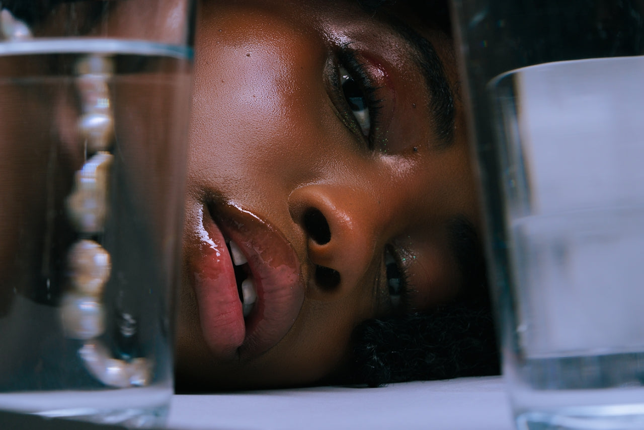 A young woman compares two glasses of electrolytes in water