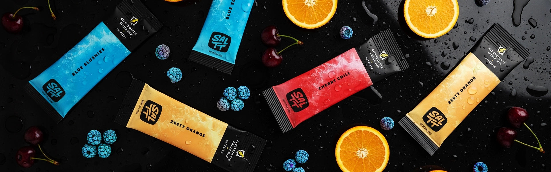 SALTT Electrolyte Drink Mix stick packs: Blue Slushies (blue), Cherry Chill (red), Zesty Orange (orange). White water splash design on wet black with fruit.