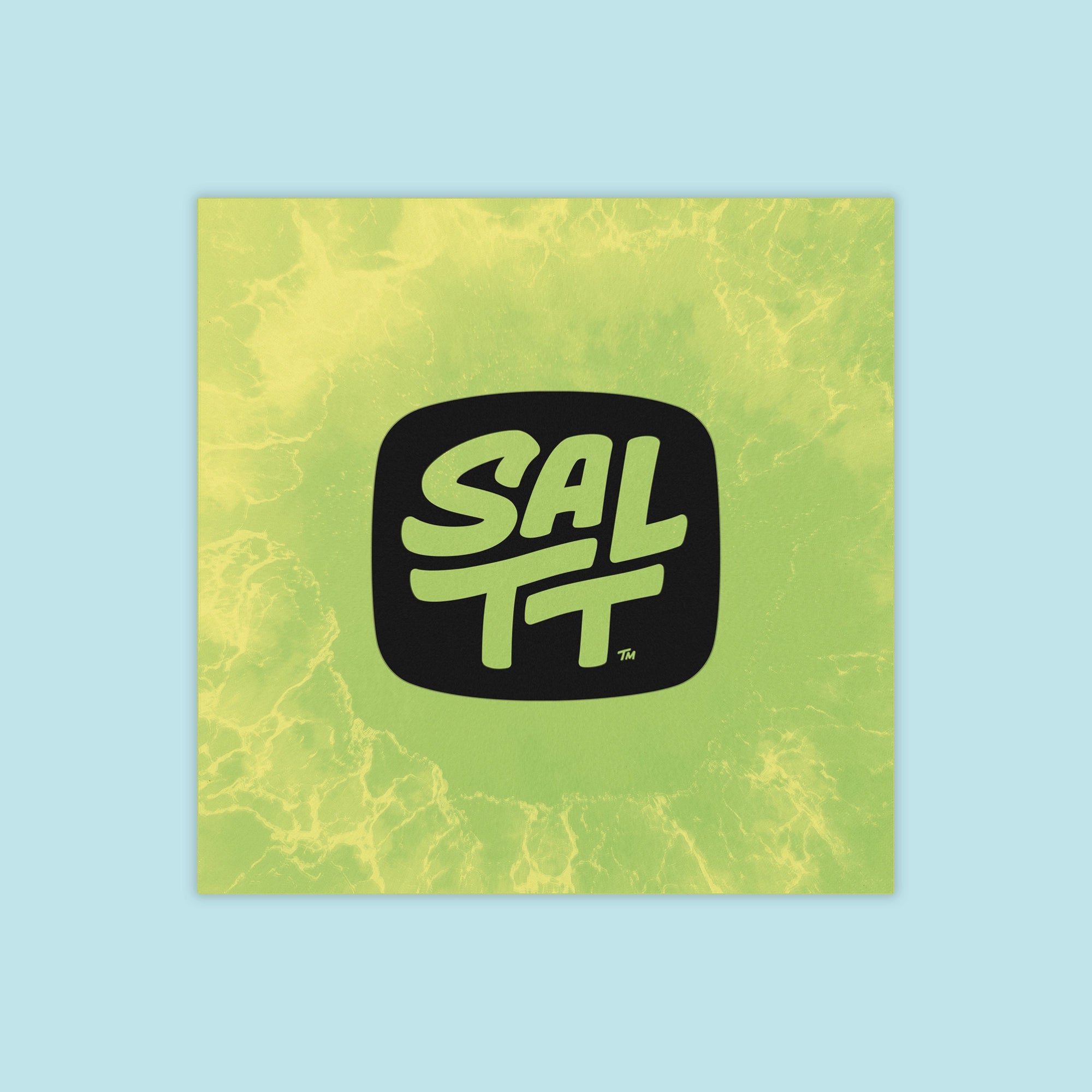 SALTT square product packaging with a black SALTT logo and TM symbol on a lime green background featuring a yellow ocean water splash pattern.