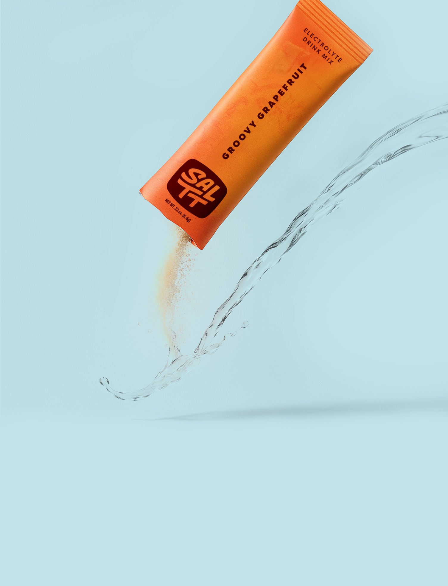 SALTT Groovy Grapefruit drink mix packet being poured into water on a light blue background