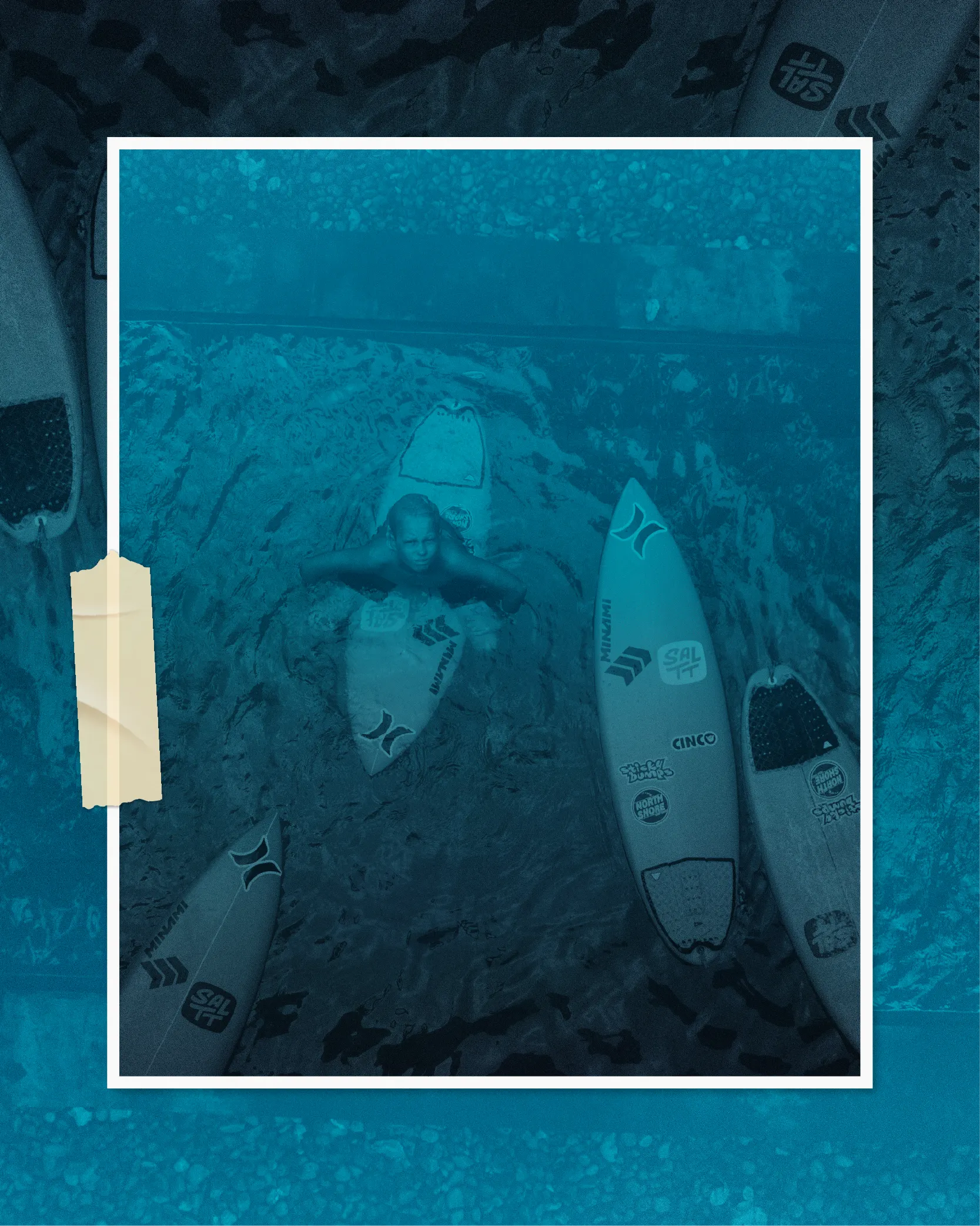 A person in blue ocean water with several surfboards, some showing the SALTT brand logo. The water has a distinct ocean splash pattern.