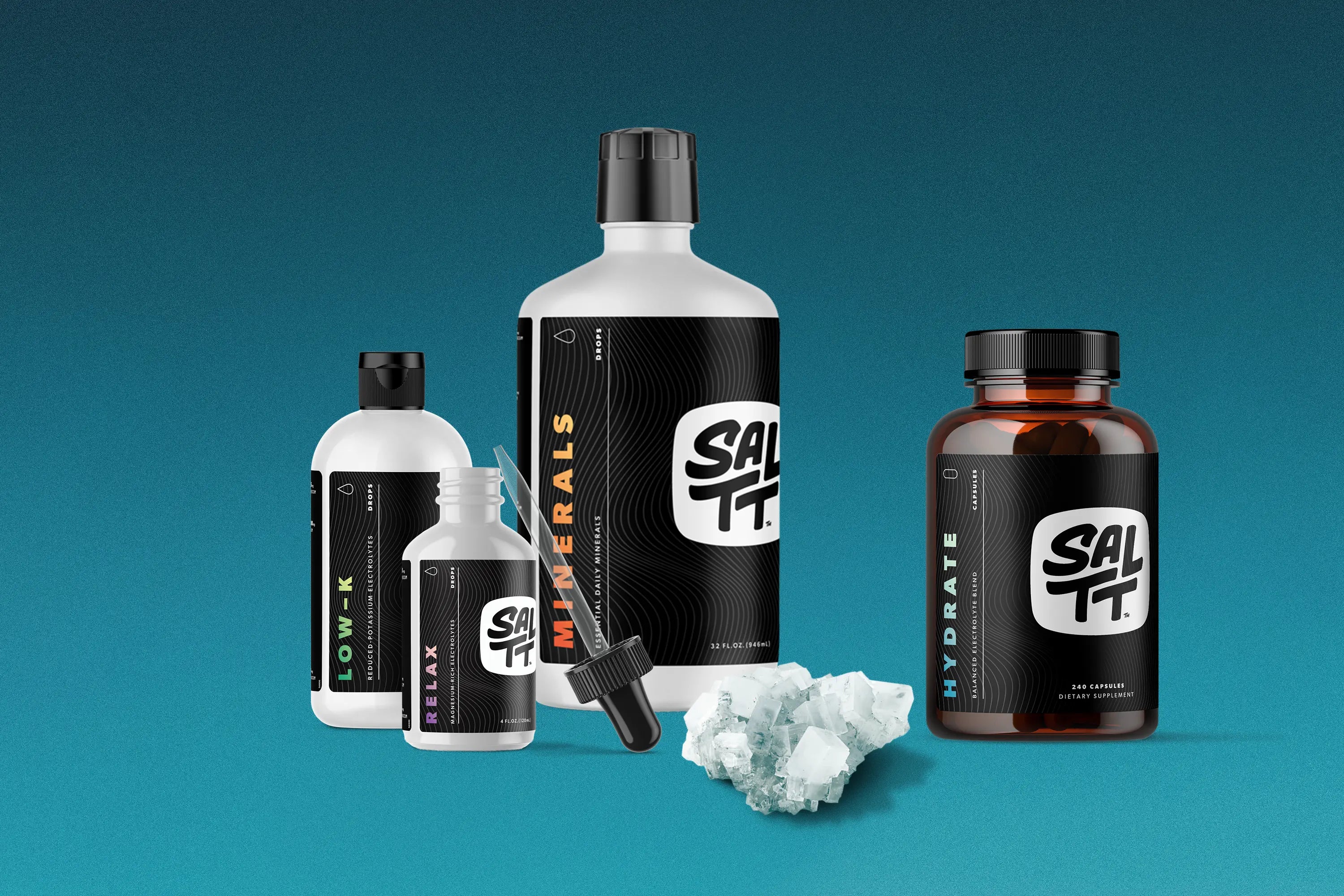 Four SALTT brand supplement products and white salt crystals are arranged on a blue gradient background. Products include a large white SALTT MINERALS Essential Daily Minerals bottle (32 FL. OZ.), a white SALTT LOW-K Reduced-Potassium Electrolytes bottle, a white SALTT RELAX Magnesium-Rich Electrolytes dropper bottle (4 FL. OZ.), and an amber SALTT HYDRATE Balanced Electrolyte Blend 240 Capsules bottle. All black labels display the white SALTT logo and an ocean water splash pattern.