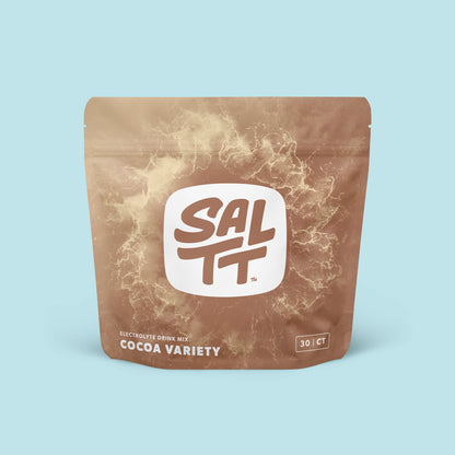 Brown stand-up pouch for SALTT Electrolyte Drink Mix, Cocoa Variety. The pouch features a lighter brown ocean water splash pattern. Centered on the pouch is a white logo with SALTT and a TM symbol in dark brown. Below the logo, light brown text states Electrolyte Drink Mix and Cocoa Variety. A 30 | CT label is on the lower right.