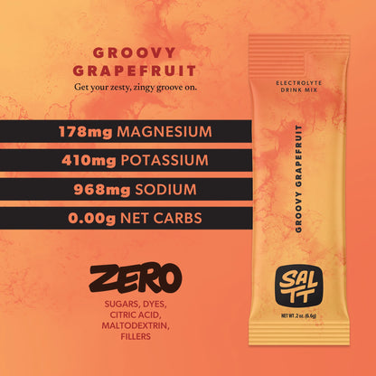 SALTT Groovy Grapefruit Electrolyte Drink Mix in an orange and yellow stick pack, featuring an ocean water splash pattern, SALTT logo, and NET WT .2 oz (6.6g). Accompanying text lists 178mg Magnesium, 410mg Potassium, 968mg Sodium, 0.00g Net Carbs, and ZERO Sugars, Dyes, Citric Acid, Maltodextrin, Fillers.