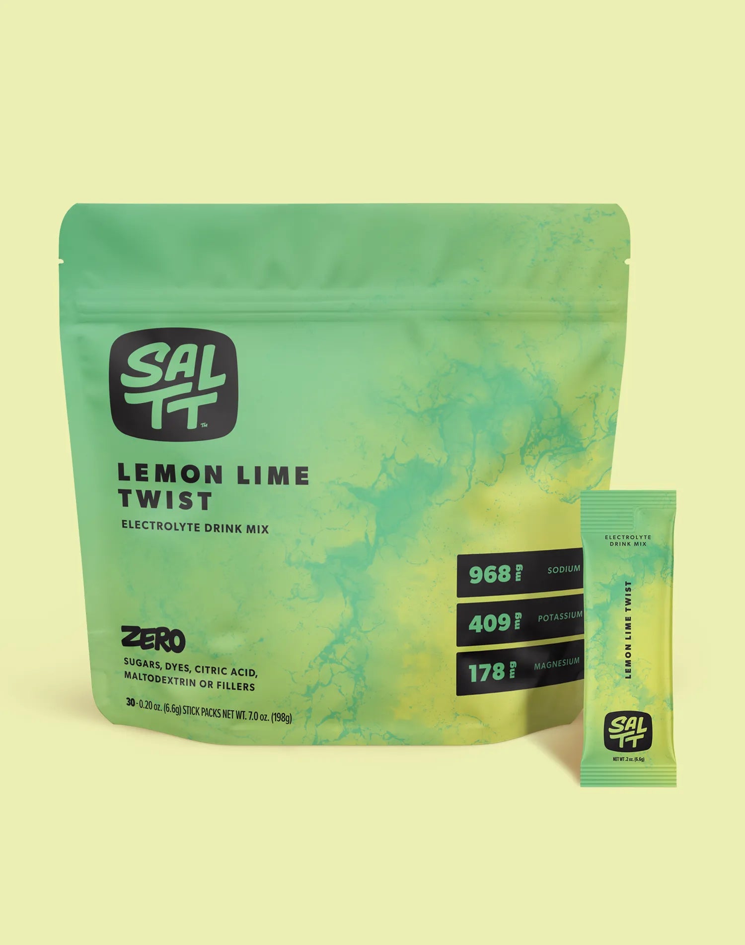 Green SALTT Lemon Lime Twist Electrolyte Drink Mix stand-up pouch with a light green ocean water splash pattern, displaying the SALTT logo, product name, 'Zero Sugars, Dyes, Citric Acid, Maltodextrin or Fillers', '30 - 0.20 oz. (6.6g) Stick Packs Net Wt. 7.0 oz. (198g)', and electrolyte content for Sodium, Potassium, and Magnesium. A matching single-serving stick pack stands to the right.