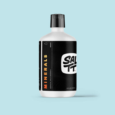 SALTT Minerals drops in a white bottle with a black cap. The black label features a white SALTT logo, orange MINERALS text, and a subtle ocean water splash pattern. Other visible text includes DROPS, ESSENTIAL DAILY MINERALS, and 32 FL. OZ. (946ML).