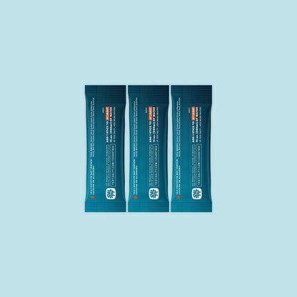Three teal SALTT stick-pack pouches featuring a light blue ocean water splash graphic and white text for brand and product information.