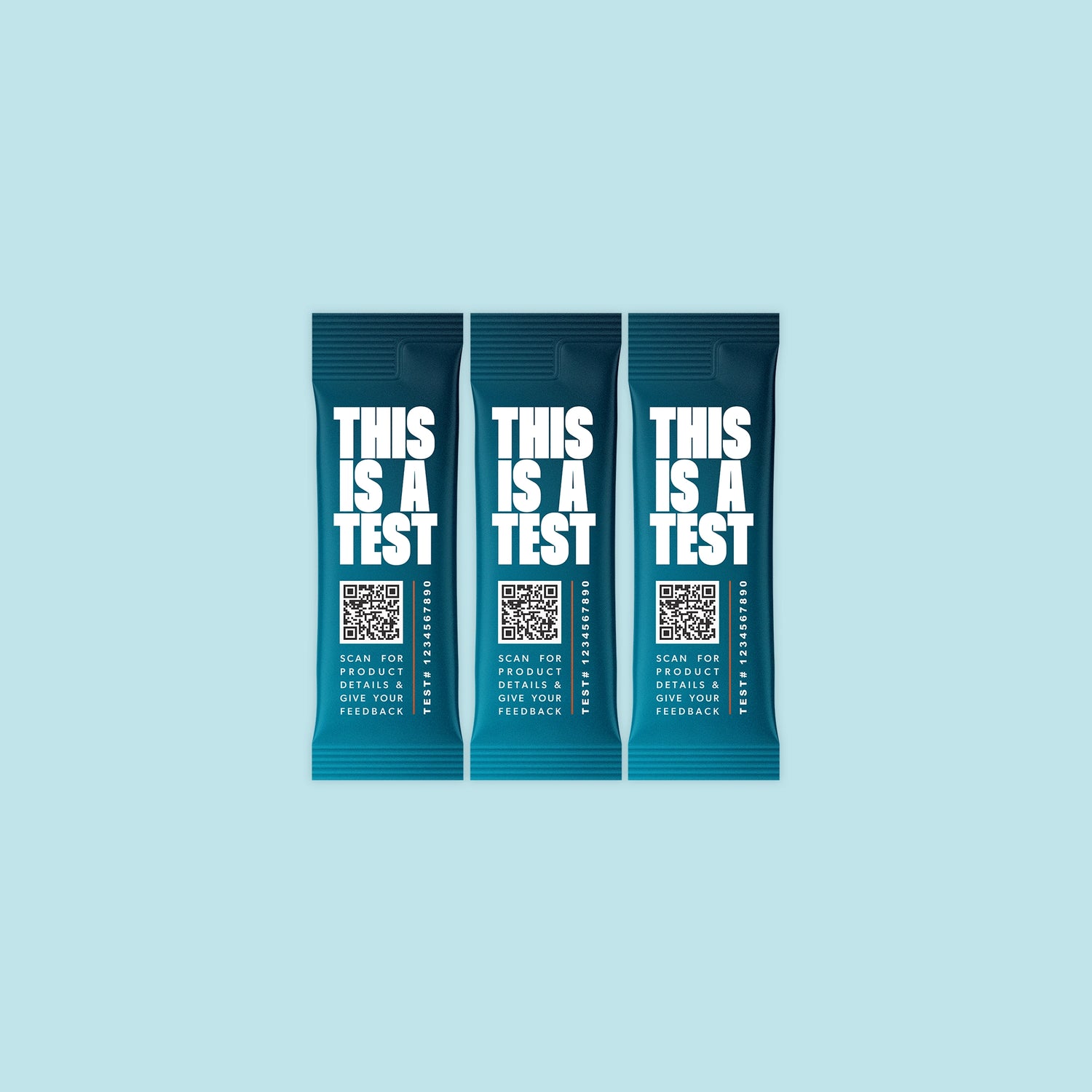 Three identical deep teal single-serve packets. Each features THIS IS A TEST in large white text, a QR code, the phrase SCAN FOR PRODUCT DETAILS & GIVE YOUR FEEDBACK, and TEST# 1234567890.