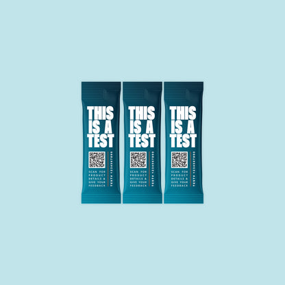 Three identical deep teal single-serve packets. Each features THIS IS A TEST in large white text, a QR code, the phrase SCAN FOR PRODUCT DETAILS & GIVE YOUR FEEDBACK, and TEST# 1234567890.