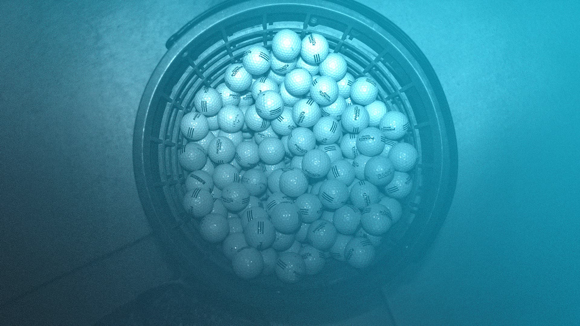 A black bucket is full of white golf balls, many marked PINNACLE PRACTICE or Callaway. The background shows a blue to teal gradient.