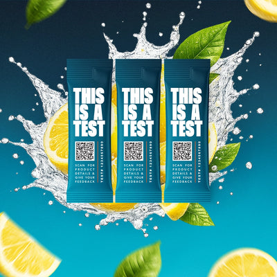 Three SALTT Lemon electrolyte stick packs, teal and white, on a blue water splash background with lemon slices and leaves.