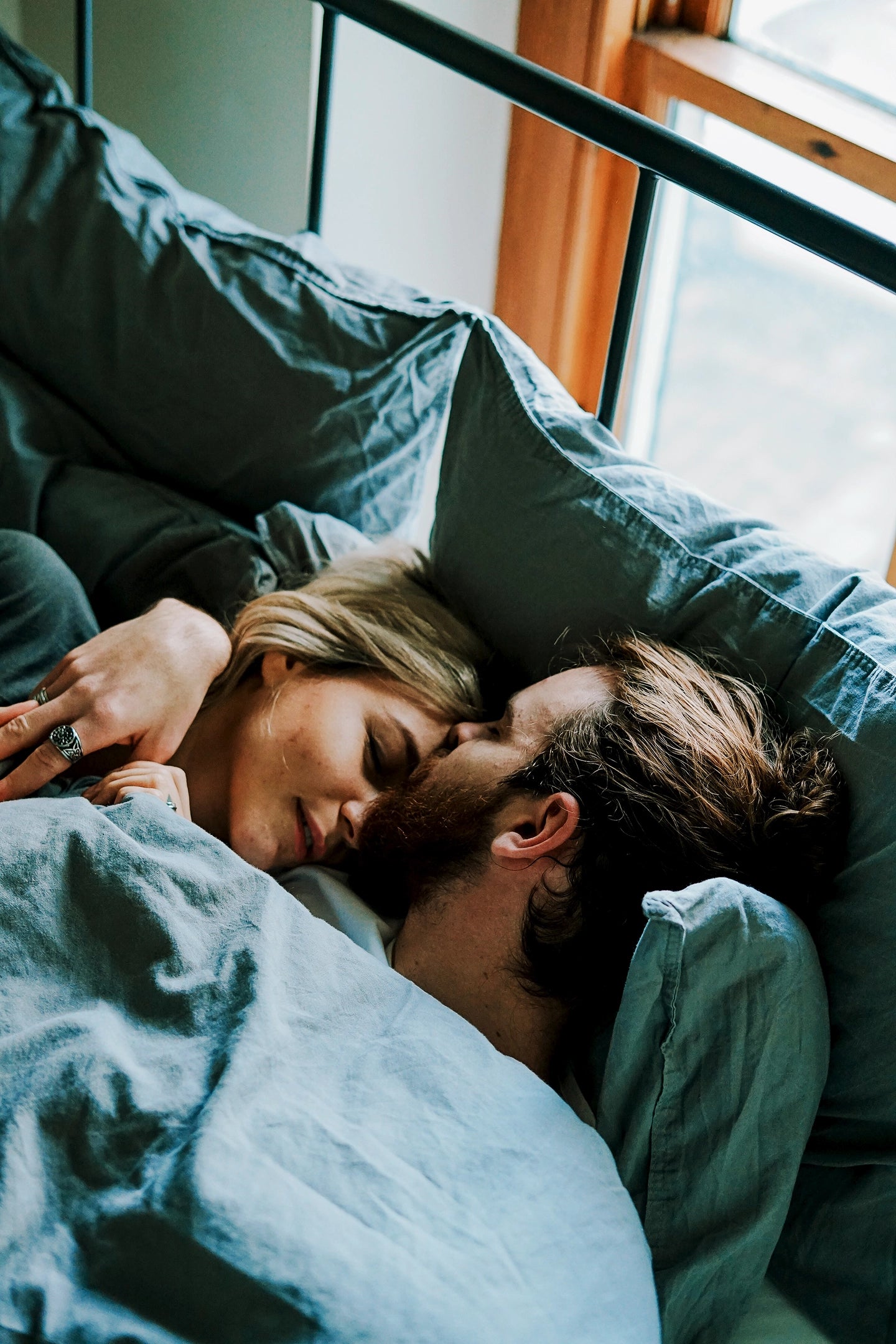 A man and eoman asleep in bed together.